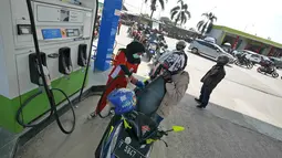 Petugas mengisi bahan bakan ke sepeda motor pemudik di SPBU kawasan Brebes, Jawa Tengah, Minggu (2/6/2019).  Sejumlah SPBU di Brebes terpantau ramai oleh para pemudik yang mengisi bahan bakar kendaraannya. (Liputan6.com/Herman Zakharia)