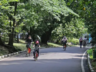 Pengunjung bersepeda di Kebun Raya Bogor, Jawa Barat, Selasa (7/7/2020). Kebun Raya Bogor menerapkan pemesanan tiket secara daring serta kapasitas pengunjung dibatasi hanya 50 persen. (Liputan6.com/Herman Zakharia)