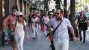 Pejalan kaki berlarian dikejar kawaan badut dalam 'Running of the Clowns' di Pasadena, California pada 21 Oktober 2018. Lari dikejar kawanan badut ini merupakan parodi yang mengolok-olok lomba dikejar banteng di Pamplona, Spanyol. (Mark RALSTON/AFP)