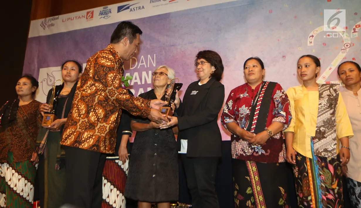 Ketua AJI Suwarjono memberikan penghargaan Tasrif Award kepada Suciwati, istri mendiang aktivis HAM Munir Said Thalib pada perayaan Ulang Tahun Aliansi Jurnalis Independen (AJI) Indonesia, di Jakarta, Senin (07/08). (Liputan6.com/Angga Yuniar)