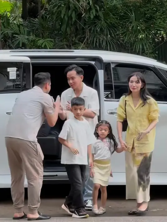Ibu Wakil Presiden, Selvi Ananda, tampil elegan dan stylish dengan perpaduan kemeja panjang warna kuning pastel dan straight skirt bermotif dalam nuansa butter. Ia hadir bersama sang suami, Gibran Rakabuming Raka, dan dua anak mereka, menunjukkan gaya keluarga yang serasi dan anggun. [@rieta_amilia/@syahnazs/@aaliyah.massaid].