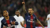 Bek Paris Saint-Germain, Dani Alves, merayakan gol ke gawang Strasbourg pada laga liga Prancis di Stadion Parc des Princes, Paris, Minggu (7/4). Kedua tim bermain imbang 2-2. (AP/Francois Mori)