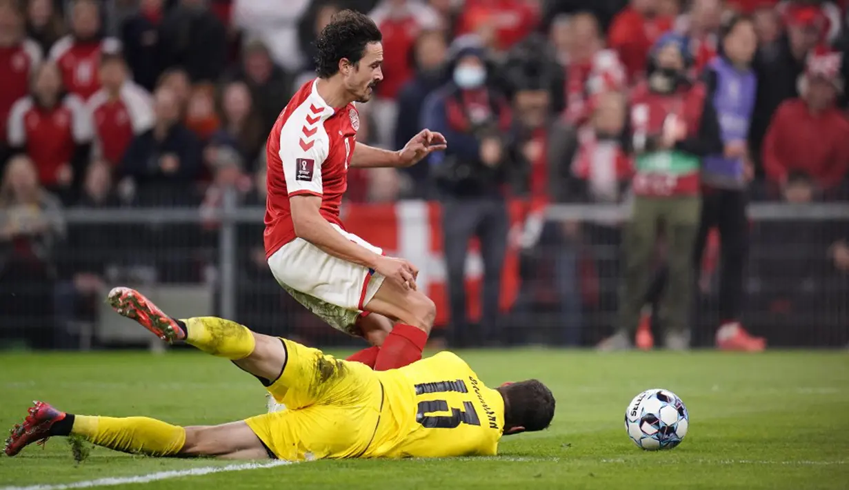 Pemain Denmark Thomas Delaney (kiri) memperebutkan bola dengan penjaga gawang Austria Daniel Bachmann pada pertandingan Grup F kualifikasi Piala Dunia 2022 di Kopenhagen, Denmark, Selasa (12/10/2021). Denmark menang 1-0. (Liselotte Sabroe/Ritzau Scanpix/AFP)