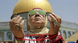 Seorang wanita Palestina berdoa di depan Kubah Shakhrah yang berada di tengah kompleks Masjid Al Aqsa, Yerusalem (8/6). Mereka memanfaatkan hari Jumat terakhir di bulan Ramadan untuk berdoa dan salat berjemaah di Masjid Al Aqsa. (AP/Mahmoud Illean)