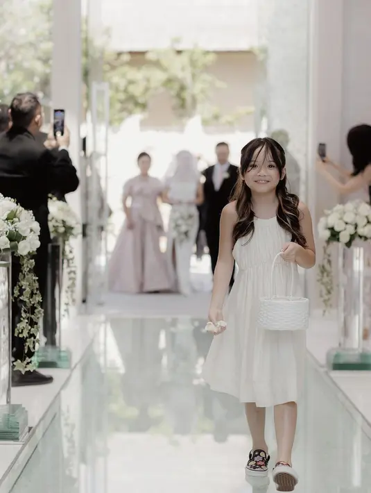 Tidak hanya pengantin yang tampil cantik mencuri perhatian, tapi juga anak Gading Marten dan Gisel, Gempi  yang menajdi flower girl.  Gempi tampil begitu cantikdan anggun berjalan membawa bunga sambil mengumbar senyum manisnya. [Instagram/gritteagathaa]