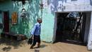 Seorang pria membawa sepatunya saat melintasi banjir di daerah perumahan dekat tepi Sungai Yamuna yang meluap di New Delhi, India, Selasa (20/8/2019). (AFP Photo/Sajjad Hussain)