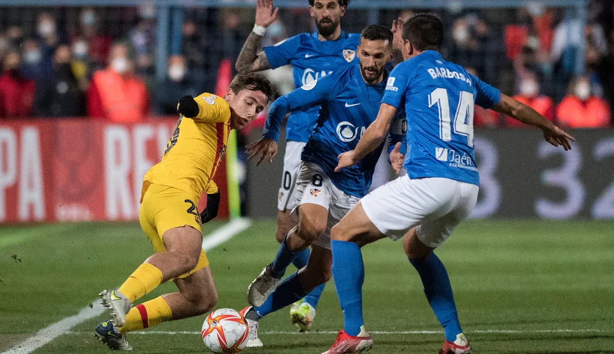 Gelandang Barcelona Nico Gonzalez berebut bola dengan pemain Linares Deportivo, Rodri (tengah) dan Alvaro Barbosa (kanan) pada babak 32 Besar Copa del Rey di Estadio Linarejos, Kamis (6/1/2022) dini hari WIB. Barcelona susah payah menang 2-1 atas tim divisi 3 Linares Deportivo (JORGE GUERRERO / AFP)