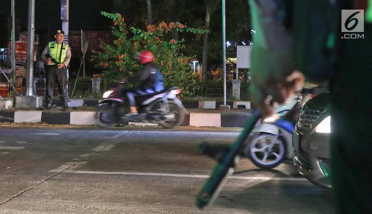 Polisi bersenjata berjaga di pos pelayanan terpadu Operasi Ketupat Lodaya 2019, Jalan Raya Pantura, Cirebon, Jawa Barat, Sabtu (1/6/2019). Polisi mengerahkan sekitar 182.000 personel selama Operasi Ketupat Tahun 2019 dalam rangka pengamanan Hari Raya Idul Fitri. (Liputan6.com/Herman Zakharia)