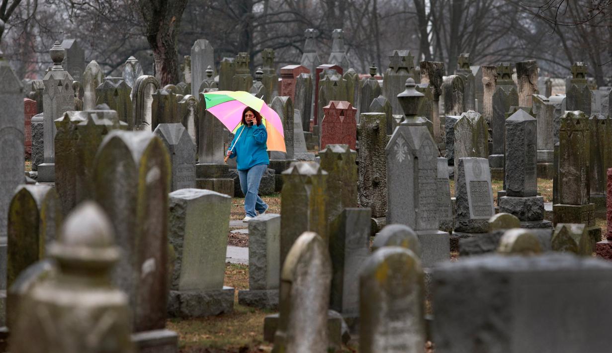 Warga mencari kuburan orang yang dicintainya di Chesed Shel Emeth Cemetery di University City, St Louis, Missouri, (21/2). Setidaknya lebih dari 100 batu nisan rusak di pekuburan itu. (Robert Cohen /St. Louis Post-Dispatch via AP)