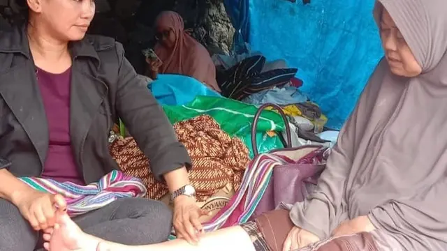 Murni memberikan terapi totok kesehatan kepada korban gempa Cianjur