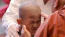 Reaksi bocah laki-laki saat rambutnya dicukur seorang biksu pada seremonial ulang tahun Buddha di kuil Jogye, Seoul, Rabu (2/5). Sepuluh anak terpilih mendapatkan pengalaman menjadi biksu dalam rangkaian acara peringatan hari lahir Buddha (AP/Lee Jin-man)