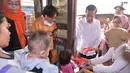 Presiden Jokowi membagikan sejumlah buku saat meninjau rumah evakuasi balita di kawasan 5 Ulu, Palembang, Sumsel, Jumat (30/10). Jokowi melihat langsung kondisi rumah evakuasi balita yang terpapar kabut asap. (Laily Rachev_Setpres)