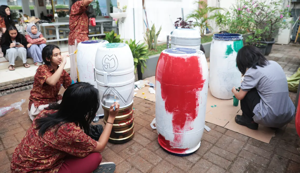 Sejumlah siswa komunitas perkusi Labsky Kebayoran "Dungtakravara" mengecat alat musik berbahan daur ulang di SMA Labschool Kebayoran, Jakarta Selatan, Kamis (23/7/2026). Drum plastik bekas, galon air mineral, diolah menjadi alat musik dan dekorasi panggung untuk drama musikal Skylite serta pentas seni Skyavenue 2026. (KLY/ Budy Santoso)