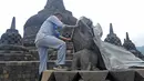 Seorang pekerja menutup stupa di kompleks candi Borobudur, Magelang, Jawa Tengah, Senin (23/11/2020). Penutupan candi Borobudur oleh BKB (Balai Konservasi Borobudur) sebagai langkah antisipasi melindungi batu candi dari abu vulkanik jika Gunung Merapi erupsi. (Photo by Agung Supriyanto/AFP)
