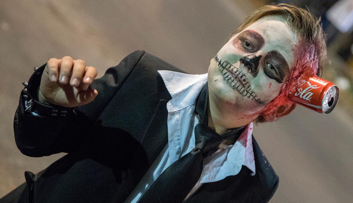 Seorang bocah mengenakan kostum serta mengecat wajahnya hingga mirip zombie mengikuti perayaan hari Purim di Tel Aviv (11/3). Liburan Purim ini dirayakan dengan parade dan pesta kostum. (AFP/Jack Guez)