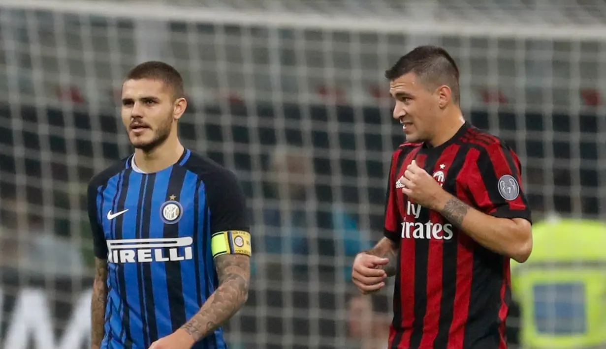 Pemain Inter Milan, Mauro Icardi berjalan melewati pemain AC Milan, Alessio Romagnoli, usai berhasil mencetak gol pada pekan kedelapan Liga Italia di Stadion Giuseppe Meazza, Minggu (15/10). Gol Inter Milan diborong oleh Icardi, 3-2. (AP/Antonio Calanni)