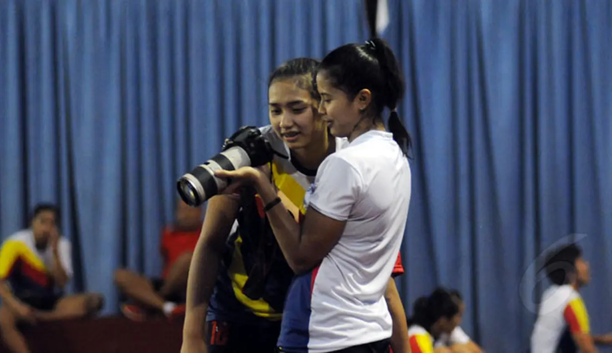 Jelang perhelatan Pertamina Proliga 2015, tim putri Jakarta Electric PLN berlatih di Aula P3B PLN Cinere, Depok, Kamis (28/1/2015). Yolla Yuliana (kiri) melihat foto dokumentasi usai berlatih. (Liputan6.com/Helmi Fithriansyah)