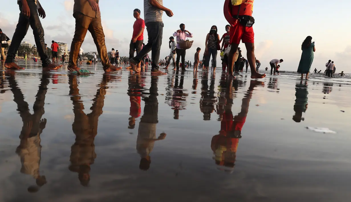 Orang-orang berjalan di Pantai Juhu, Mumbai, India, Selasa (24/8/2021). India mencatat penambahan 14.419 kasus positif COVID-19 pada 24 Agustus 2021. (AP Photo/Rafiq Maqbool)