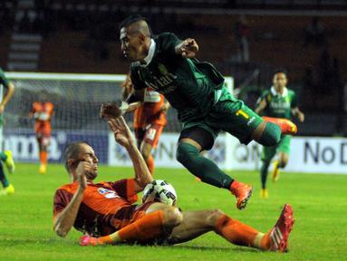 Winger Persebaya Siswanto harus melompat untuk menghindari tekel bek jangkung Pusamania Martin Kovachev. (Liga Indonesia)