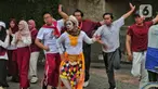 Sejumlah mahasiswa melakukan paduan suara dan gerak tari saat Car Free Day, di Jakarta, Minggu (25/9/2022). Pagelaran ini merupakan bentuk pengenalan seni kepada masyarakat yang tengah melakukan aktivitas di CFD. (Liputan6.com/Angga Yuniar)