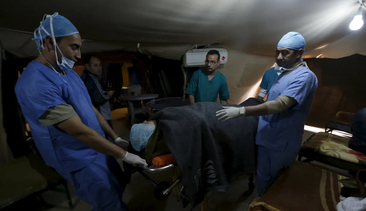 Dokter bersiap melakukan operasi cesar pada seorang wanita Suriah di kamp pengungsi Al Zaatari, Yordania, 7 Maret 2016. Menurut UNHCR, semenjak krisis di Suriah sekitar 50-80 bayi lahir setiap minggunya di kamp pengungsi Zaatari. (REUTERS/Muhammad Hamed)