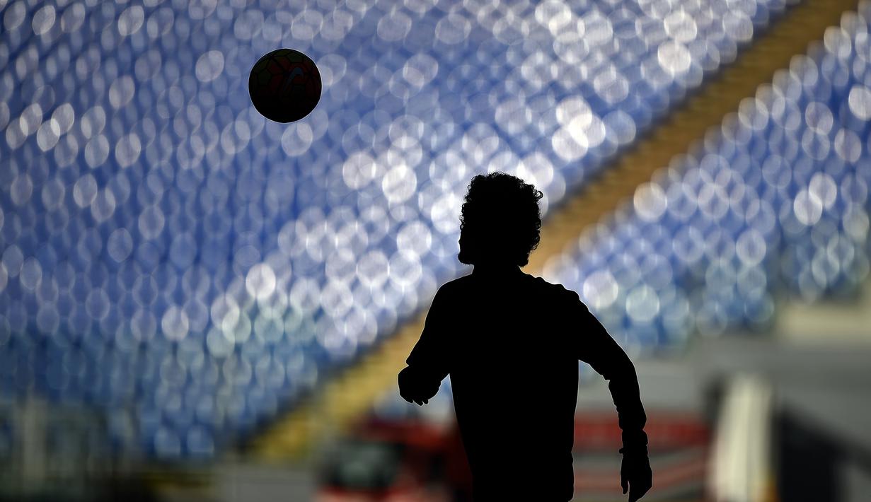 Siluet seorang pemain saat melakukan pemanasan jelang pertandingan antara AS Roma melawan Lazio dalam lanjutan Serie A di Stadion Olimpico, Roma, Minggu (8/11/2015) malam WIB. (AFP Photo/Filippo Monteforte)
