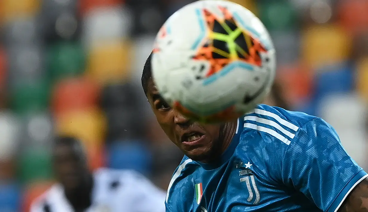 Gelandang Juventus, Douglas Costa menyundul bola saat bertanding melawan Udinese pada pertandingan lanjutan Liga Serie A Italia di Stadion Dacia Arena di Udine (23/7/2020). Udinese menang 2-1 atas Juventus. (AFP Photo/Marco Bertorello)