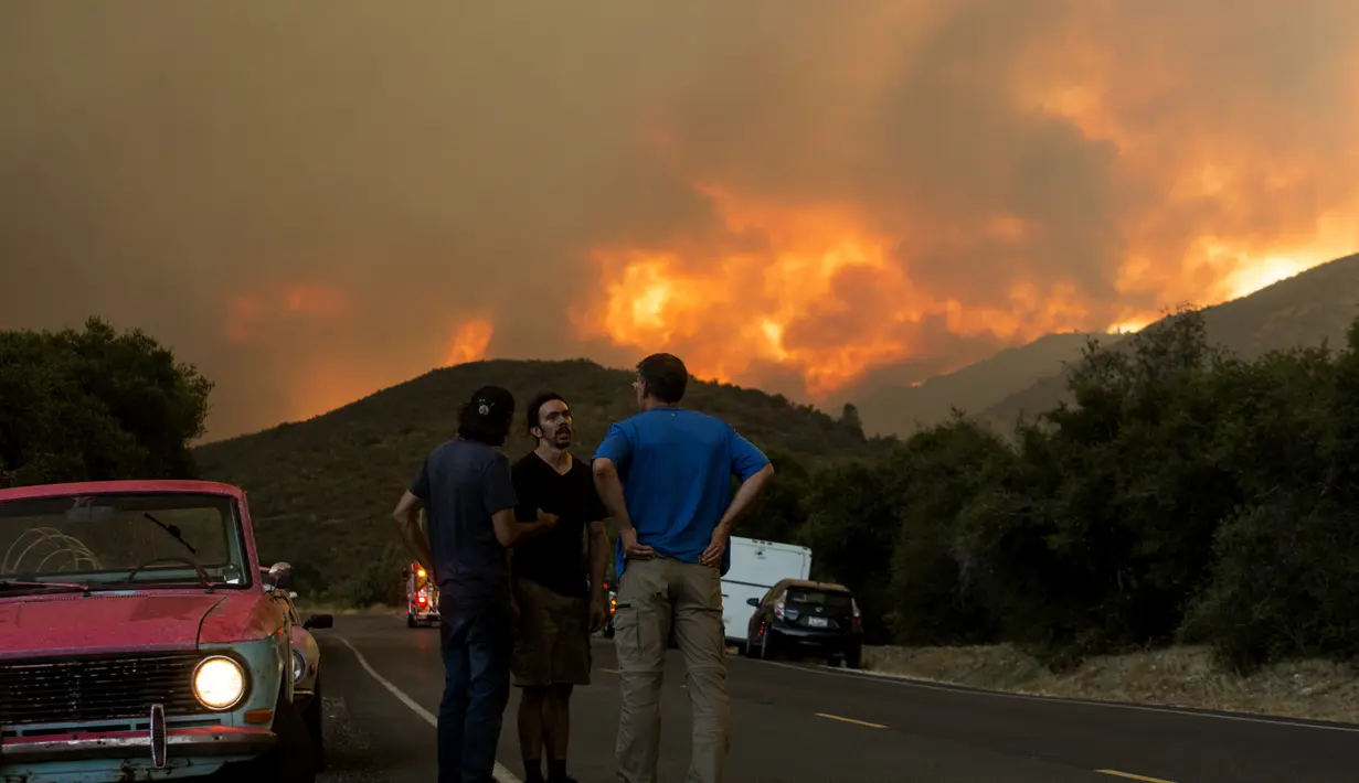 Warga berkumpul dan berbincang saat api membakar Hutan Nasional Angeles di California, Amerika Serikat, Rabu (12/8/2020). Kebakaran yang diberi nama Lake Fire tersebut terjadi di sekitar Danau Hughes. (AP Photo Ringo H.W. Chiu)