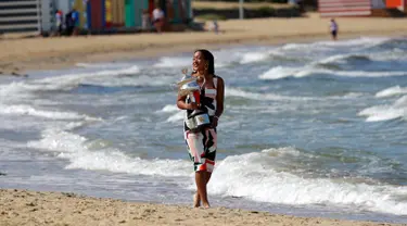 Petenis Jepang, Naomi Osaka membawa trofi juara tunggal putri Australia Terbuka 2019 di Pantai Brighton Melbourne, Australia, Minggu (27/1). Osaka meraih juara setelah mengalahkan Petra Kvitova di final. (AP Photo/Aaron Favila)