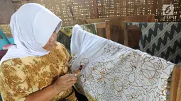 Seorang ibu membuat batik tulis di Kampung Batik Puswasedar kawasan Geopark Ciletuh, Sukabumi, Jawa Barat, Sabtu (22/9). Kaum perempuan mulai menekuni pembuatan batik mulai tahun 2015. (Merdeka.com/Arie Basuki)
