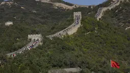 Turis menaiki bentangan Tembok Besar Badaling di pinggiran Beijing, Selasa (6/10/2020). Liburan tahun ini, yang bertepatan dengan Festival Pertengahan Musim Gugur, akan menjadi ujian lakmus apakah industri pariwisata China dapat bangkit kembali setelah digempur oleh COVID-19. (AP Photo/Ng Han Guan)