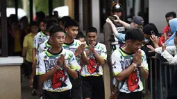 12 anak laki-laki dan pelatih sepak bola mereka, yang diselamatkan dari gua banjir di Thailand tiba menghadiri konferensi pers di Chiang Rai, Rabu (18/7). Mereka muncul di depan umum untuk pertama kalinya sejak keluar dari RS. (LILLIAN SUWANRUMPHA /AFP)
