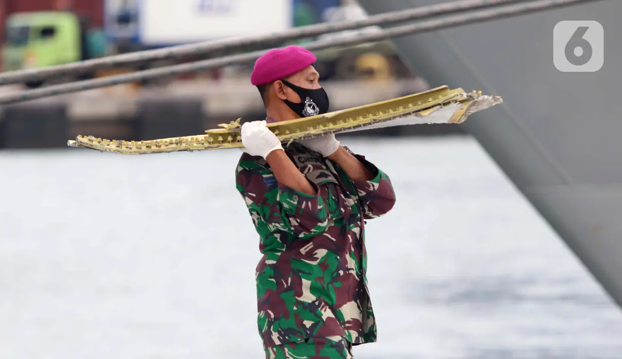 Tentara membawa serpihan pesawat Sriwijaya Air SJ 182 di Dermaga JICT 2, Jakarta, Minggu (10/1/2021). Tim selam Marinir TNI AL berhasil menemukan dan mengevakuasi serpihan pesawat Sriwijaya Air SJ 182 yang kemudian diserahkan ke Basarnas, Kepolisian, serta KNKT. (Liputan6.com/Helmi Fithriansyah)