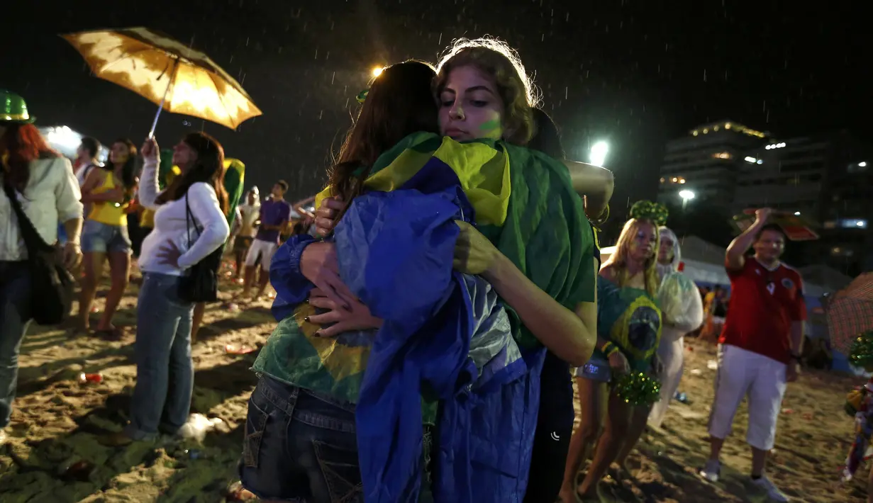 Seorang wanita terlihat merangkul temannya yang dibuat kecewa melihat aksi punggawa Brasil pada babak semifinal Piala Dunia 2014 melawan Jerman, Selasa (8/7/14). (REUTERS/Pilar Olivares) 