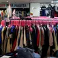 Pengunjung mencoba pakaian bekas impor yang dijajakan pedagang di Pasar Baru Metro Atom, Jakarta, Jumat (6/12/2019). Pakaian bekas impor yang dijual di kios-kios pasar masih banyak diminati lantaran harga yang ditawarkan sangat terjangkau. (merdeka.com/Imam Buhori)
