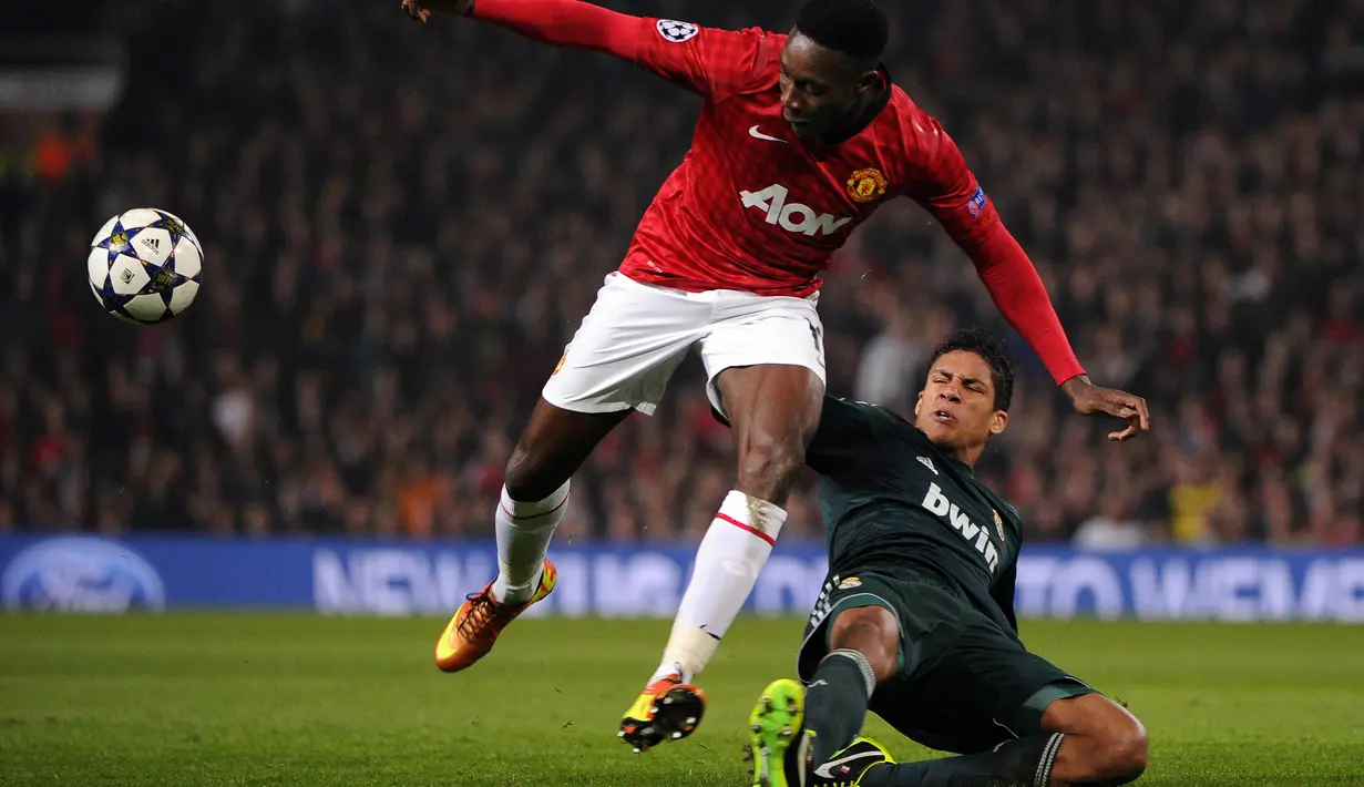 Aksi Real Raphael Varane (kanan) melakukan adangan terhadap pemain Manchester United, Danny Welbeck pada laga Liga Champions  di Old Trafford, Manchester, (5/3/2013).  (AFP/Pierre-Philippe Marcou)