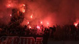 Suporter Timnas Indonesia U-19 menyalakan suar saat laga Grup A Piala AFF U-19 2022 antara Timnas Indonesia U-19 melawan Timnas Vietnam U-19 di Stadion Patriot Candrabhaga, Bekasi, Jawa Barat, Sabtu (02/07/2022). (Bola.com/Ikhwan Yanuar)