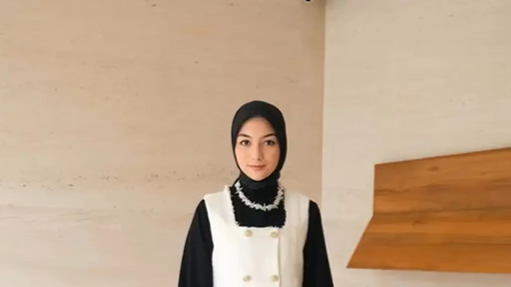 Citra Kirana terlihat feminin dengan outfit monokrom. Ia padukan kemeja long sleeve dengan pleated skirt hitam dan double breated tweed vest yang trendy [@citra_ciki]
