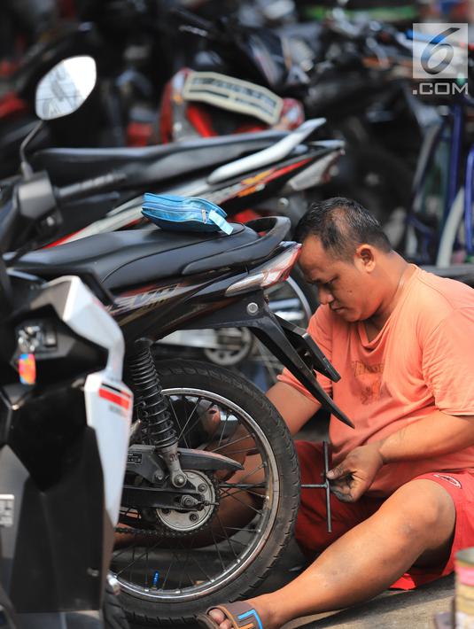 Mekanik memperbaiki motor di salah satu bengkel di Otista, Jakarta, Minggu (10/6). Calon pemudik motor mulai memenuhi bengkel guna menyervis atau mengganti suku cadang kendaraan sebelum digunakan untuk mudik Lebaran. (Liputan6.com/Angga Yuniar)