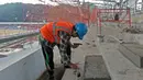 Pekerja sedang memperbaiki tangga venue Atletik Stadion Madya di Kawasan Senayan Sport Center, Jakarta (12/10/2017). Renovasi stadion tersebut untuk menyambut Asian Games 2018. (Bola.com/Nicklas Hanoatubun)