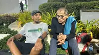 Pak Midun (kanan) berbincang dengan suporter Persebaya, Tulus, dalam perhentiannya di Surabaya sebelum melanjutkan perjalanan ke Jakarrta demi keadlian Tragedi Kanjuruhan. (Bola.com/Aditya Wany)