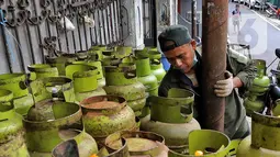 Pekerja menata tabung gas elpiji 3 kg untuk dijual kembali di kawasan Jakarta, Rabu (4/1/2023). Tahun 2023, pembelian elpiji 3 kg akan diperketat dengan menggunakan KTP. (Liputan6.com/Angga Yuniar)