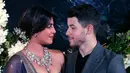 Pasangan aktris Bollywood Priyanka Chopra dan musisi Nick Jonas berpose untuk resepsi kedua pernikahan mereka di Mumbai, India, Rabu (19/12). Malam itu, Priyanka Chopra mengenakan gaun biru navy tanpa tali dengan sulaman emas. (AP/Rajanish Kakade)
