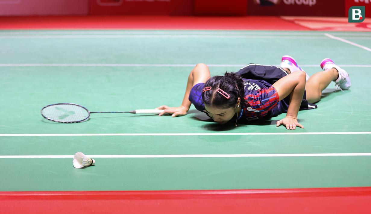 Tunggal putri bulu tangkis Indonesia, Gregoria Mariska Tunjung, terjatuh saat melawan wakil Chinese Taipei, Lin Hsiang Ti, dalam pertarungan babak 16 besar di Istora Gelora Bung Karno, Senayan, Jakarta pada Kamis (23/1/2024) sore WIB. (Bola.com/Abdul Aziz)