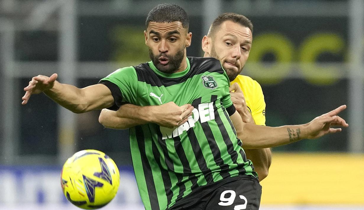 Pemain Inter Milan, Stefan de Vrij, berebut bola dengan pemain Sassuolo, Gregoire Defrel, pada laga Liga Italia di Stadion Giuseppe Meazza, Minggu (14/5/2024). Inter Milan menang dengan skor 4-2 atas Sassuolo. (AP Photo/Antonio Calanni)