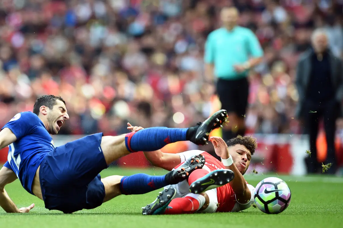 Gelandang Arsenal, Alex Oxlade-Chamberlain (kanan), menekel penggawa Manchester United (MU), Henrikh Mkhitaryan, pada laga di Emirates Stadium, Minggu (7/5/2017).