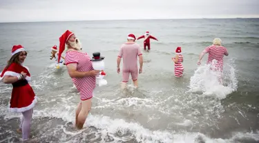 Sejumlah peserta Kongres Santa Claus Dunia 2015 berenang di pantai Bellevue di Copenhagen, Denmark, Minggu (21/7/2015). (REUTERS/Scanpix Denmark/Erik Refner)