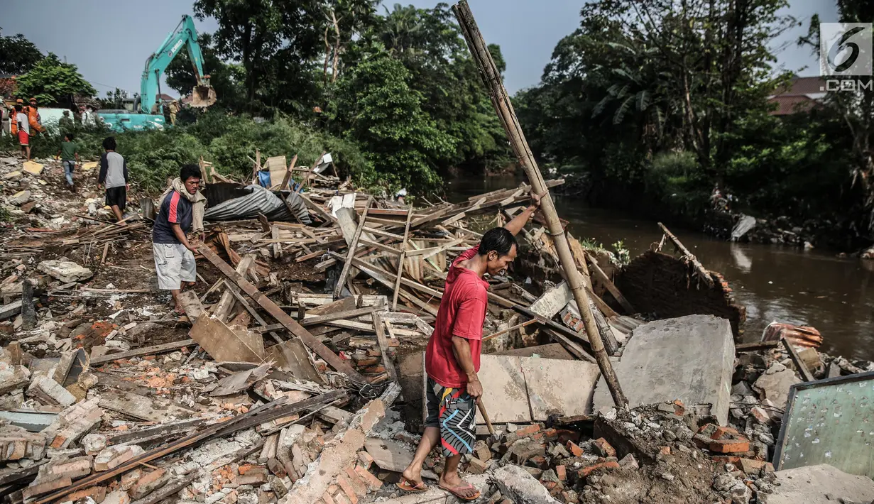 Sejumlah warga mengumpulkan kayu bekas sisa penertiban bangunan di bantaran Sungai Ciliwung, kawasan Bukit Duri, Jakarta Selatan, Selasa (11/7). Terdapat 355 bangunan yang ditertibkan guna menanggulangi banjir di Jakarta ini (Liputan6.com/Faizal Fanani)