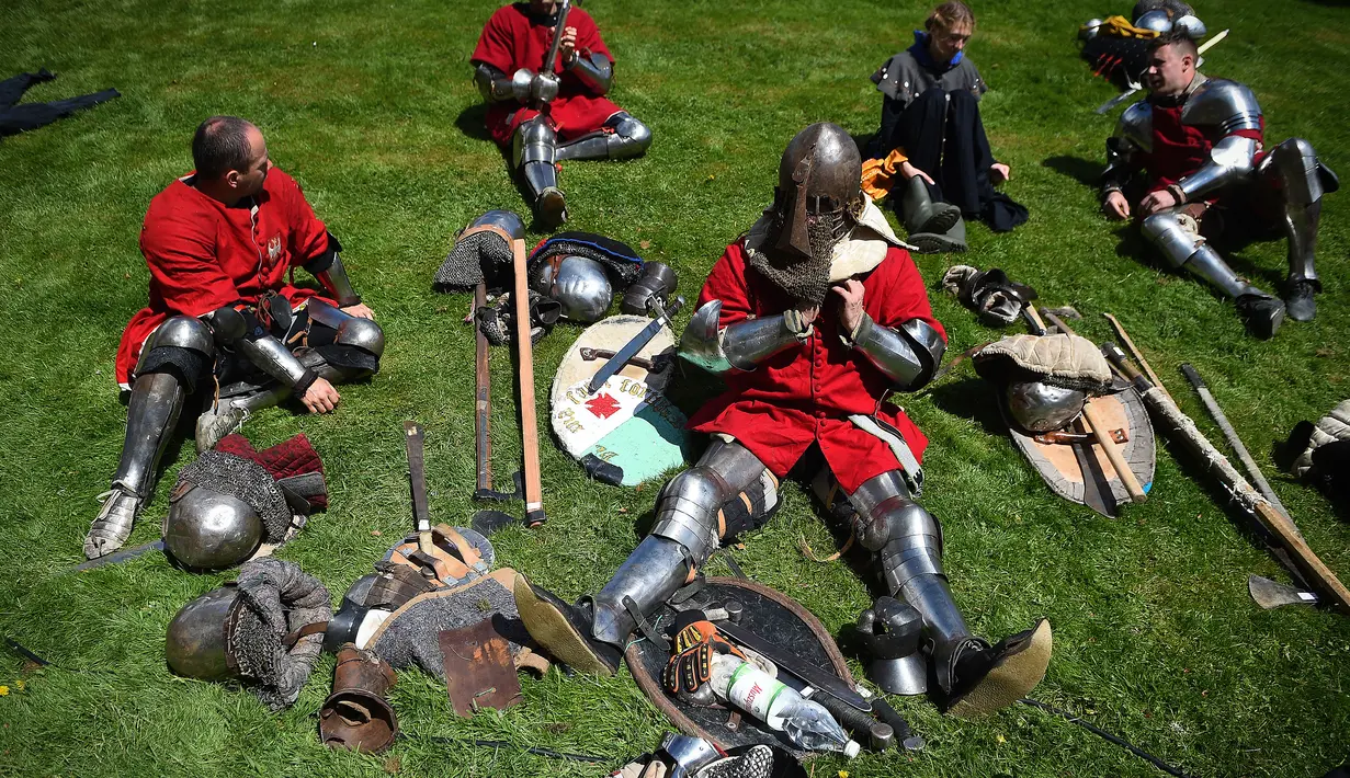 Peserta melepas baju besinya saat istirahat di sela IMCF di Scone Palace, Perthshire, Skotlandia (10/5). Dalam kompitisi ini peserta mengenakan pakaian perang abad pertengahan.(AFP/Andy Buchanan)
