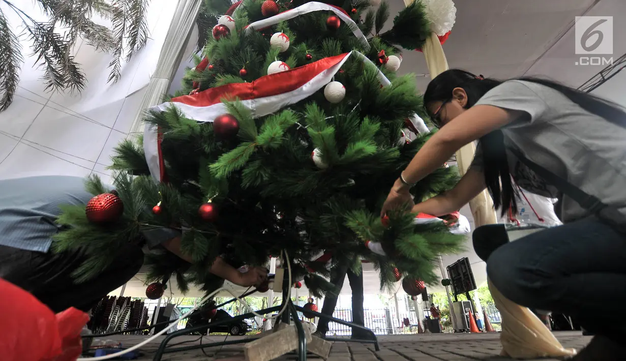 Panitia menyelesaikan pemasangan pohon Natal dan ornamen lainnya saat mendekorasi kompleks Gereja Katedral, Jakarta, Minggu (23/12). Gereja Katedral mengusung tema 'Persatuan Indonesia' dalam perayaan Natal tahun ini. (Merdeka.com/Iqbal S Nugroho)
